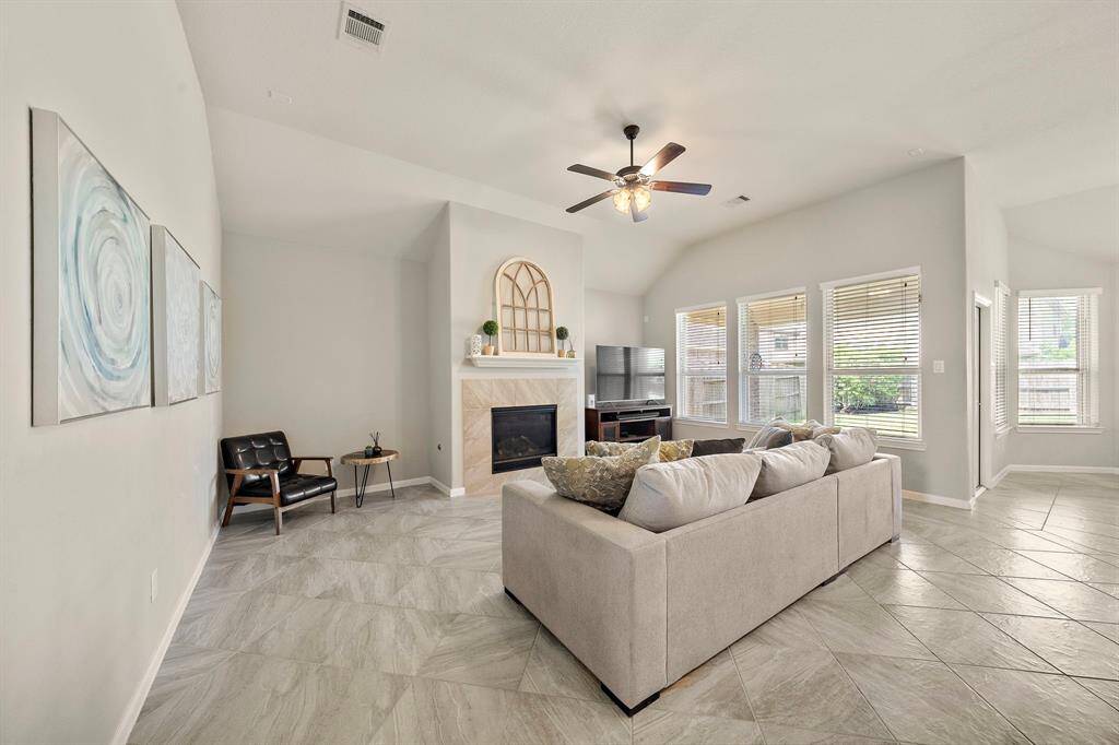 The living room features a gaslog fireplace and a wall of windows allowing for plenty of natural light to come in.