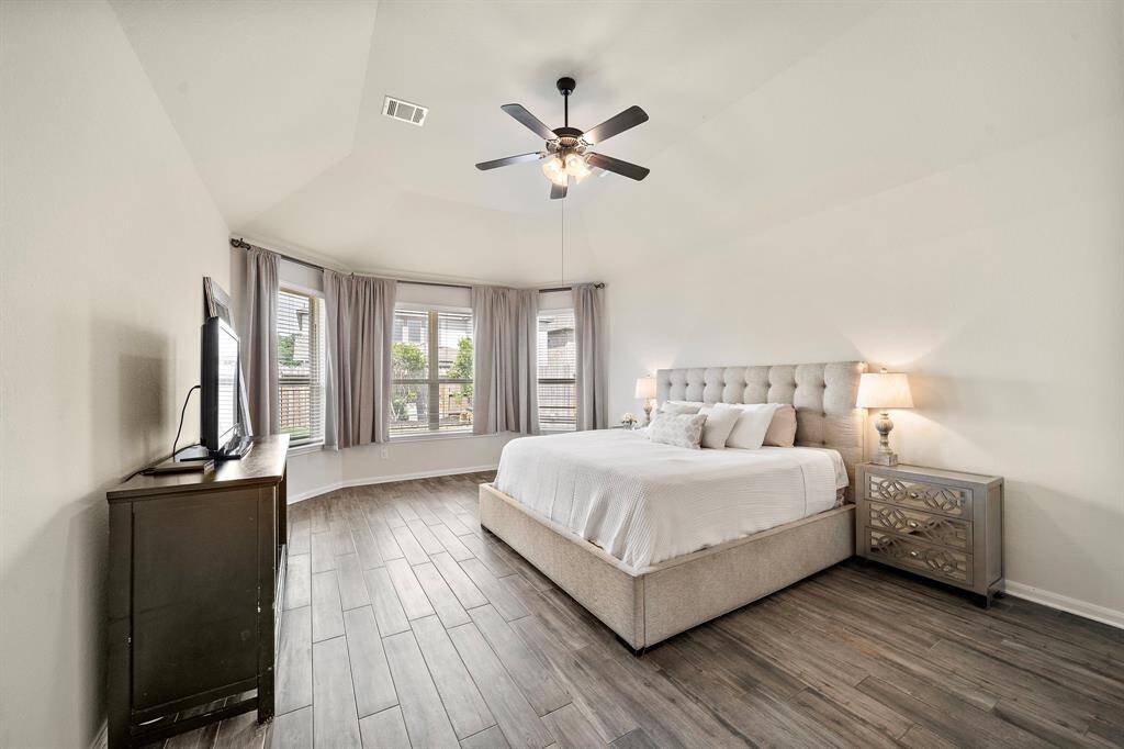 Gorgeous primary retreat featuring wood look tile and bay windows.