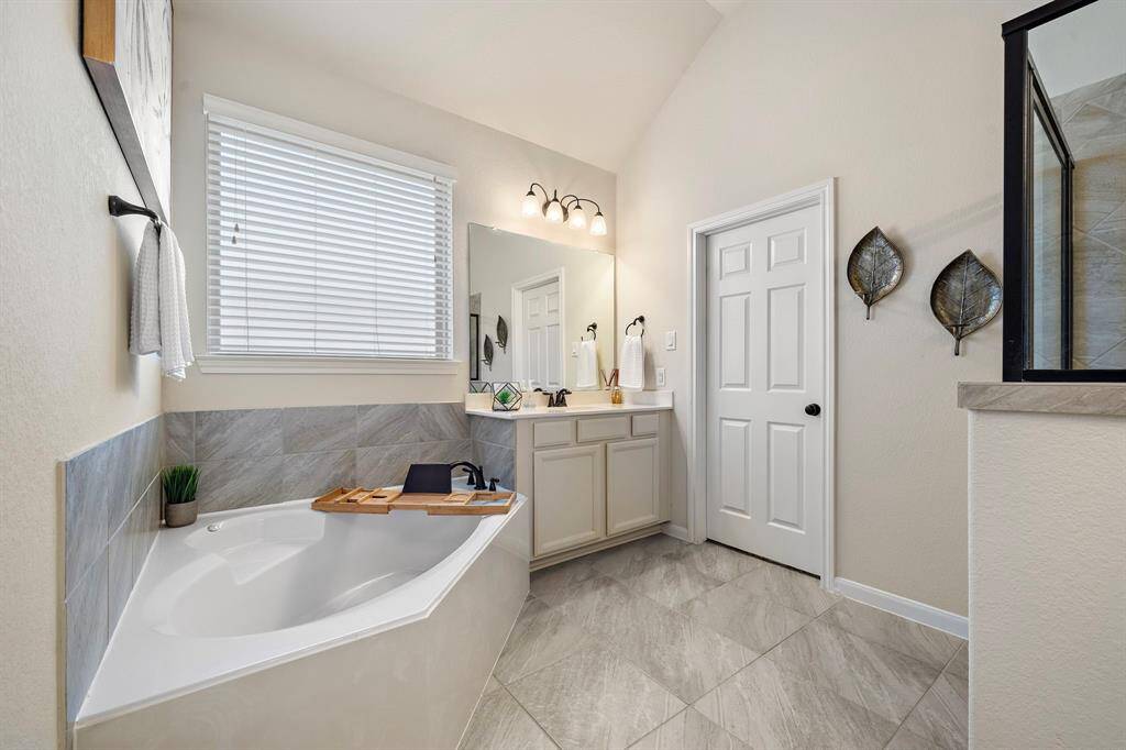 The primary bathrooms features 2 vanity areas, a soaking tub, and seperate shower.
