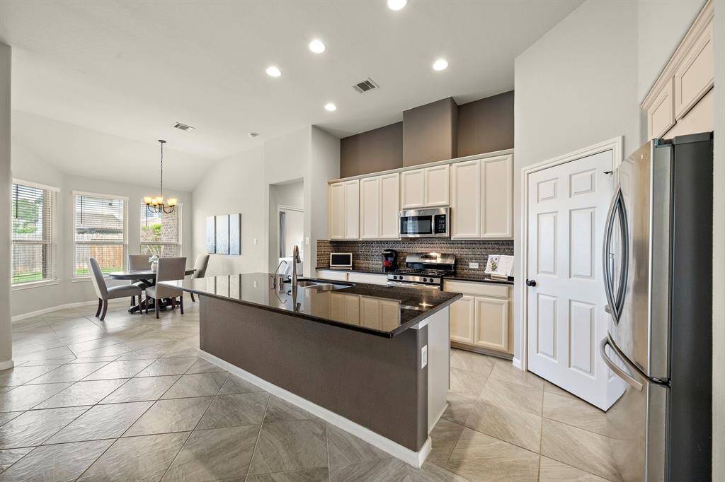 The kitchen features stainless steel appliances and a walk-in pantry.