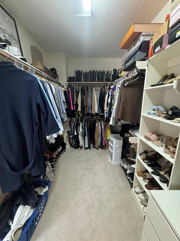 Primary closet with built ins and vast storage space
