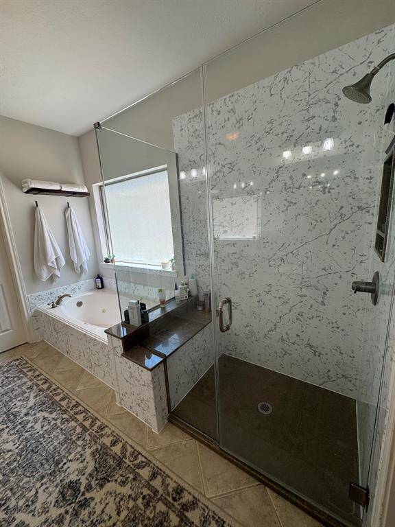 Oversized shower with bench, separate jetted tub and natural light