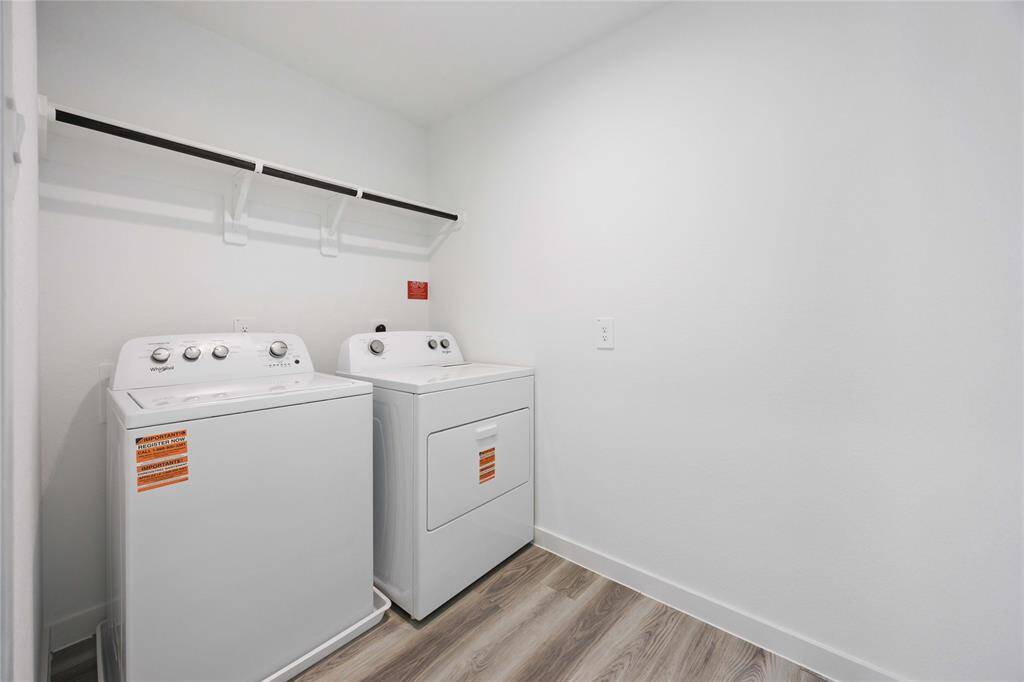 Upstairs laundry room conveniently located near all bedrooms, offering built-in shelving and ample space for added storage and organization