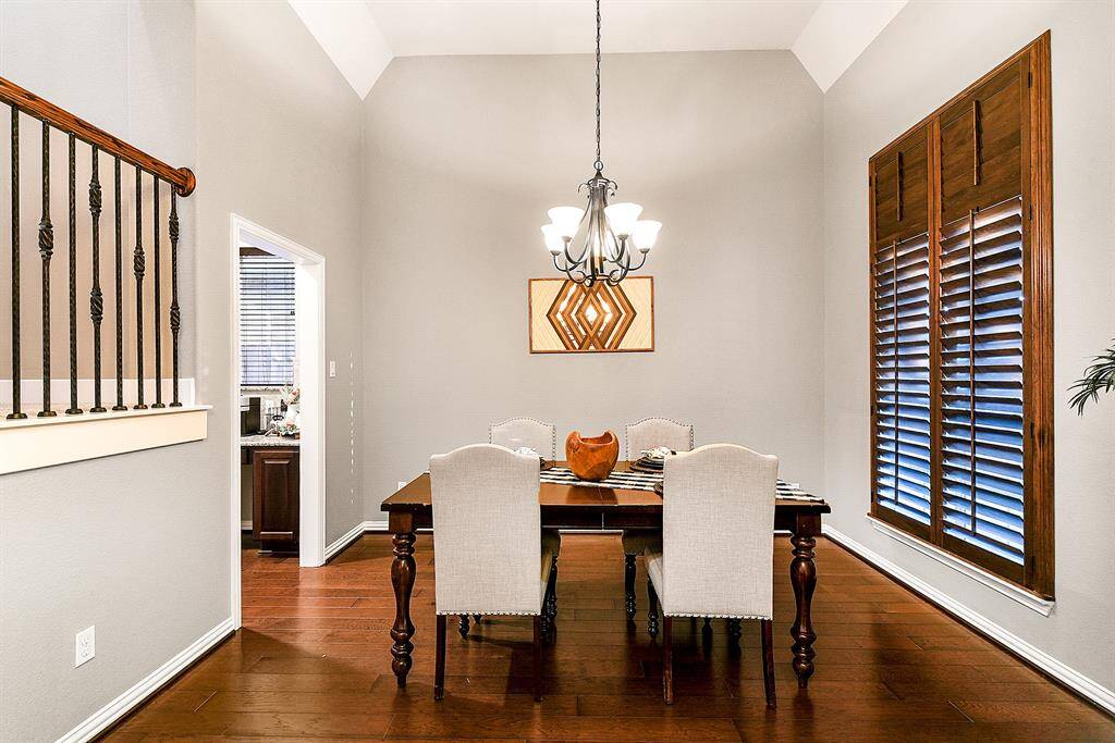 The spacious formal dining room easily accommodates a large dining set, making it ideal for hosting gatherings and special occasions. Three expansive windows overlook the front yard with custom wood shutters, flooding the room with natural light and creating a warm, inviting atmosphere. Enjoy convenient access to the kitchen with a two-way entry design that enhances the homes functionality.