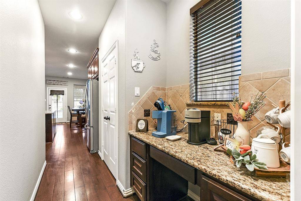 Between the dining room and kitchen, you'll find a versatile butler’s pantry/study nook featuring a window and space for seating—perfect for a coffee station or a stylish wine bar. This walk-through area provides seamless access from the dining room to the kitchen, with a large pantry conveniently located just to the right.