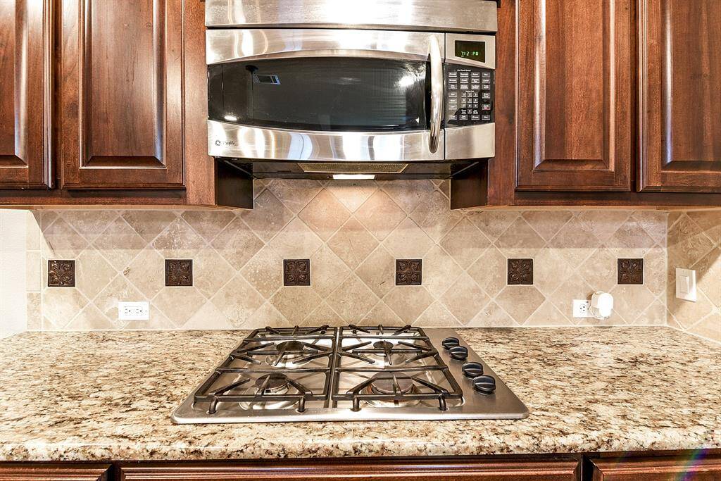 This stunning kitchen comes fully equipped with stainless steel appliances, including a built-in wall double oven and a gas cooktop—ideal for the home chef.