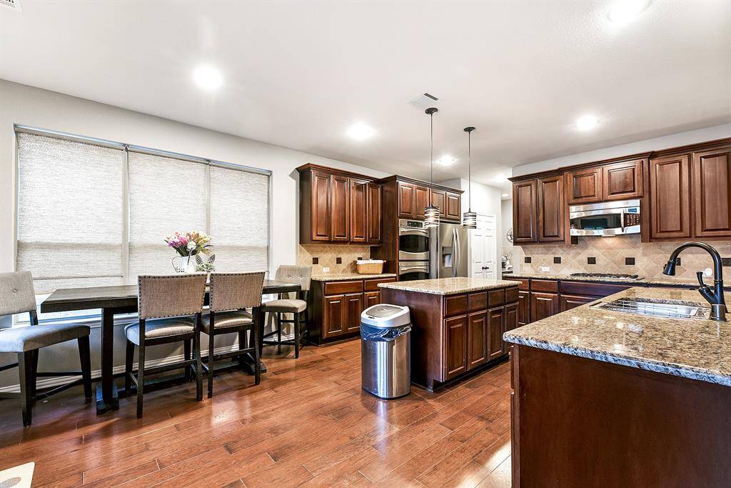 Seamlessly open to the breakfast area and living room, this kitchen is perfect for those who love an open, connected layout. The spacious breakfast room is ideal for casual meals and morning coffee, with plenty of room for a large table. You'll also notice the same elegant wood flooring flowing throughout the main floor, creating a cohesive and warm atmosphere that ties the spaces together beautifully.