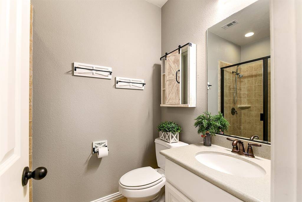 The guest bathroom on the first floor features a standing shower and is located next to the main floor guest bedroom.
