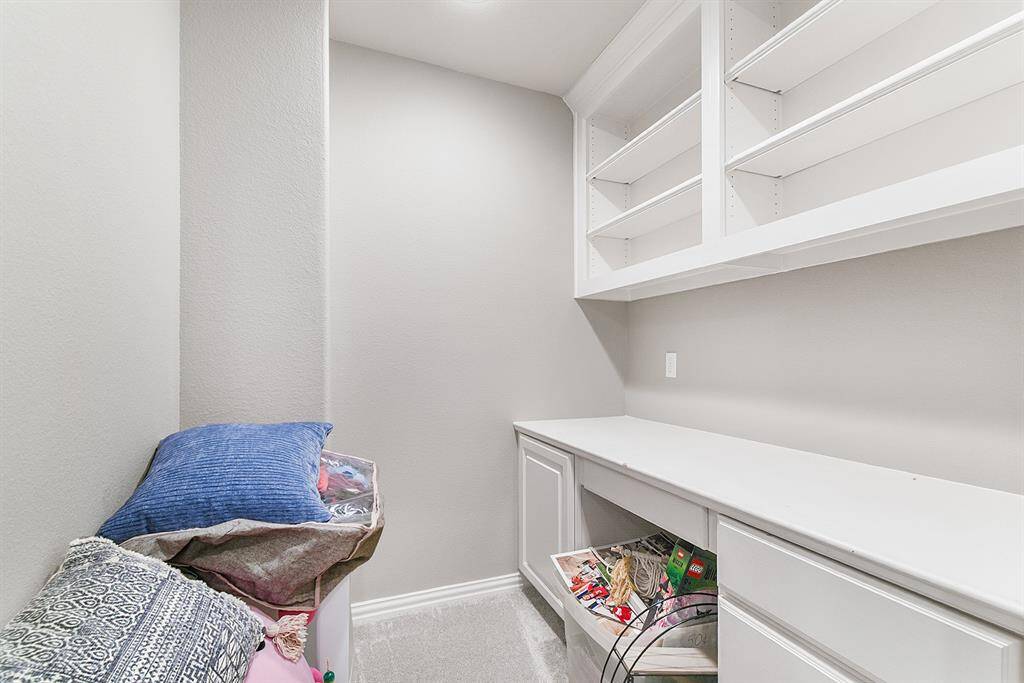 The second work space in the home is an upstairs nook located off the game room. It features a built-in desk and shelving for additional storage, providing an ideal spot for productivity or a quiet retreat to work or study.