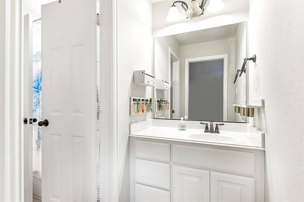 The Hollywood-style bathroom is conveniently shared by both upstairs bedrooms, offering each room its own sink and vanity for added privacy and convenience.