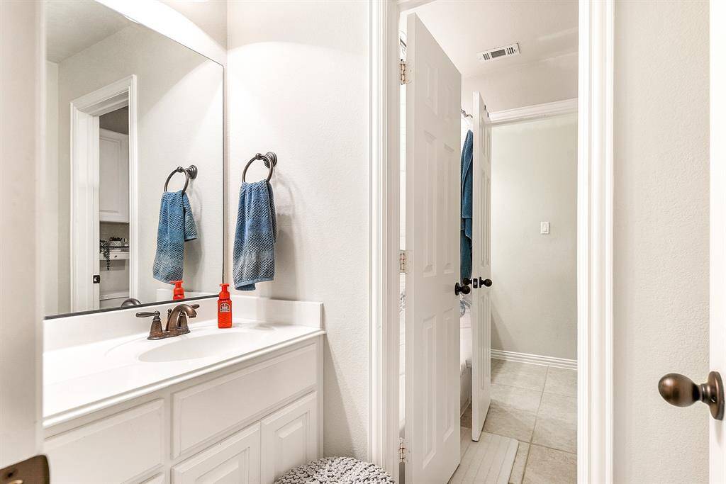 This Hollywood-style bathroom serves as a shared space for the two upstairs guest bedrooms, offering individual sinks and vanities for each room, ensuring convenience and privacy. It’s a thoughtfully designed layout that enhances functionality of the home.
