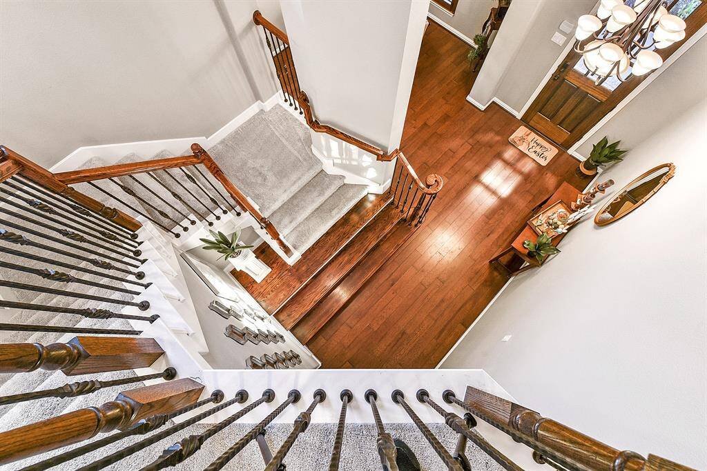 From the upstairs, enjoy a beautiful view overlooking the foyer and a clear sightline down the staircase, creating an open and airy feel that enhances the home’s spacious design.