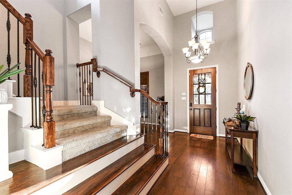 As you step inside, you’re greeted by an inviting entryway that sets the tone for the rest of the home. To the left, you'll find a formal dining room with charming front yard views, perfect for gatherings and special occasions. The space is enhanced by elegant wood flooring that flows beautifully throughout the main living areas, adding warmth and sophistication.