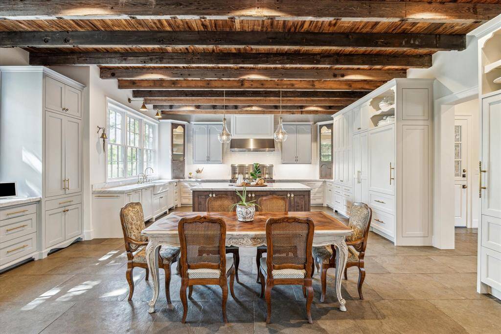 Meticulously designed kitchen is grand in scale & is truly the heart of the home. Designed with reclaimed wood ceiling & beams, bespoke cabinetry crafted to look like furniture, high-end appliances & oversize flooring.