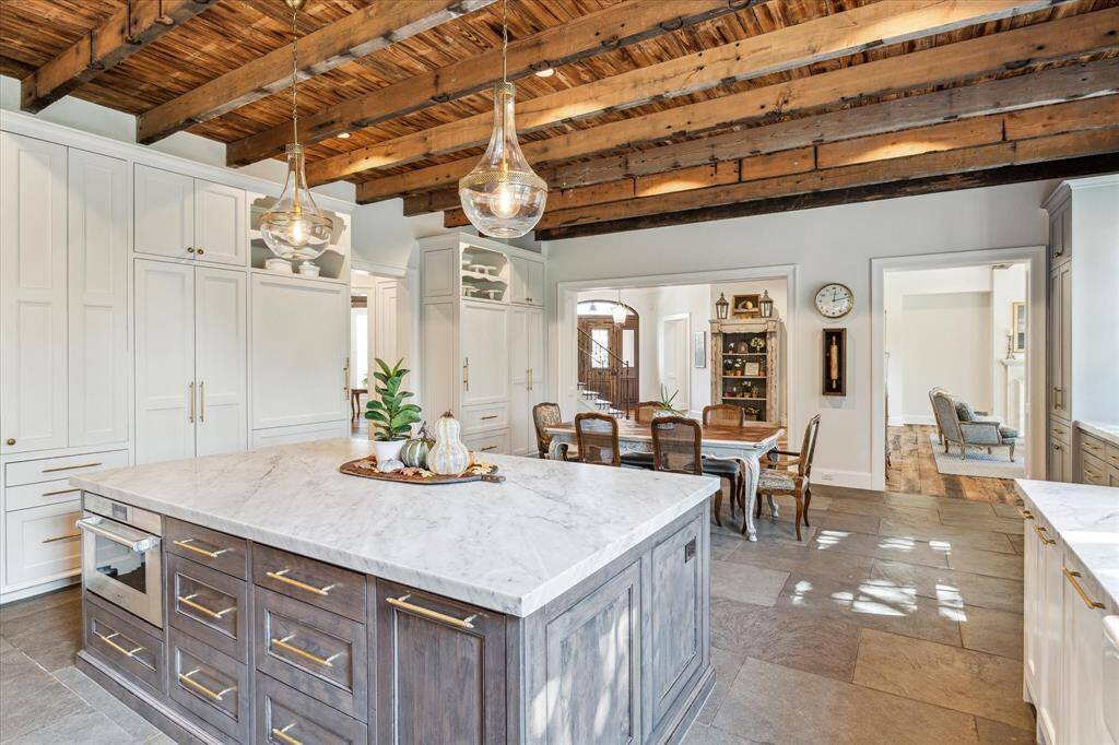 View of island boasting attractive pendant lights. Two SubZero refrigerators with freezer drawers are just behind, hidden behind custom panel fronts.