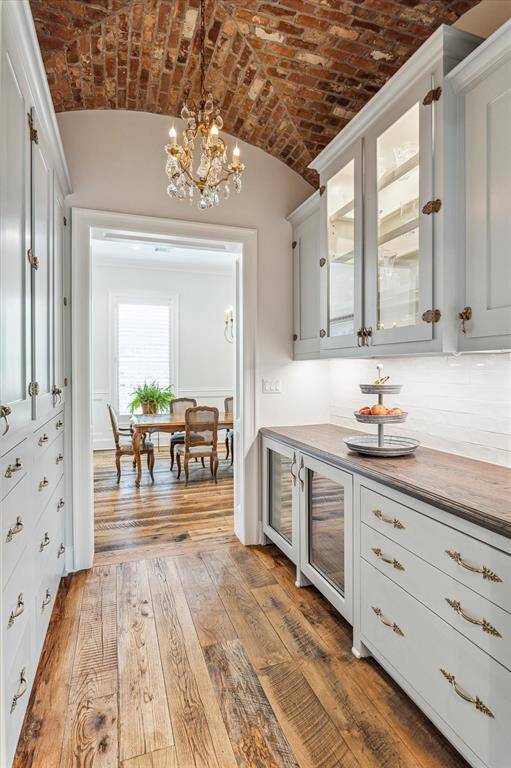 Showstopping groin ceiling in Butler's Pantry/Bar beautifully utilizes reclaimed brick. Custom oak counters, wine & beverage fridges & drawers with custom inserts for wine storage.