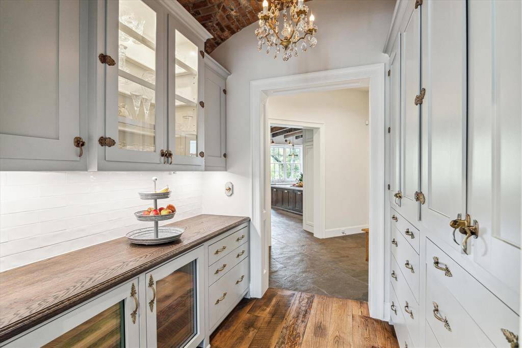 Stunningly appointed Butler's Pantry/Bar includes wall of bespoke cabinetry with custom storage & antique hardware.