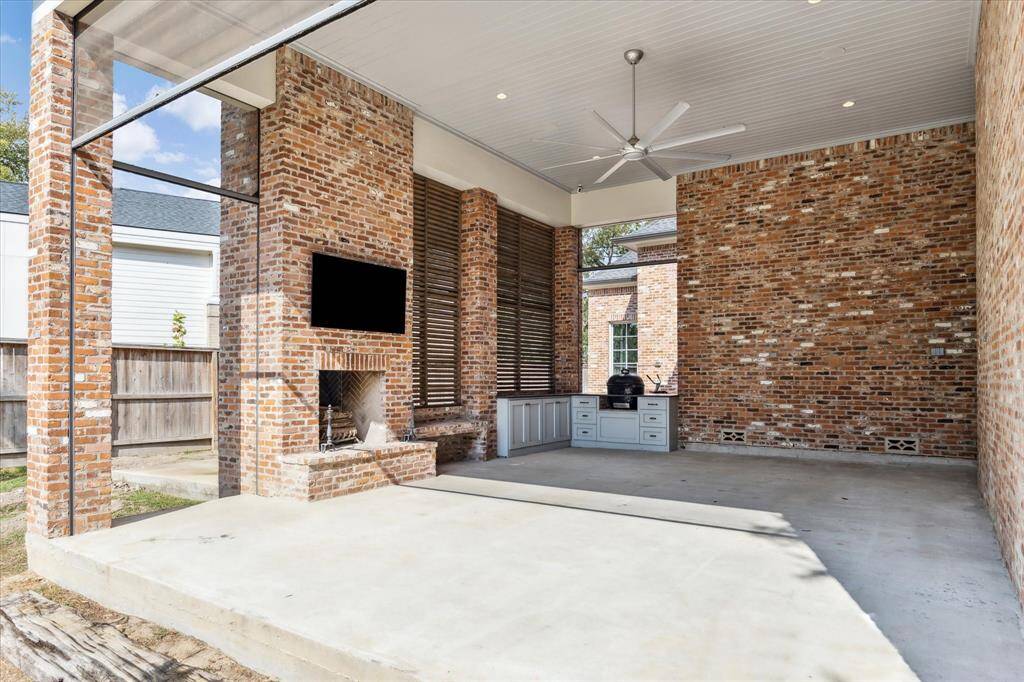 Massive outdoor covered patio boasts reclaimed brick walls, louvered wooden screens, Primo Grill, cabinetry with leather granite counters & outdoor fireplace with custom herringbone tile firebox. Convenient outdoor shower is just around the corner!