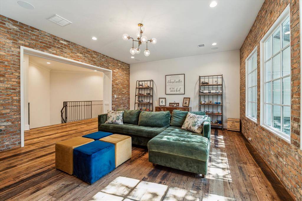 Whimsical fixture, recessed lighting & two reclaimed brick accent walls round out this wonderful game room!