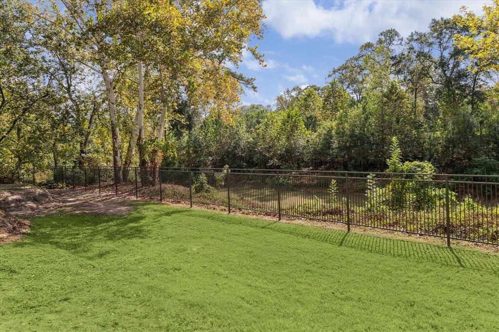 Tranquil views of Buffalo Bayou from expansive lawn offer a serene setting in the heart of Memorial. Iron fencing is designed to blend into the scenery. Home was built one foot over the Harvey flood line.