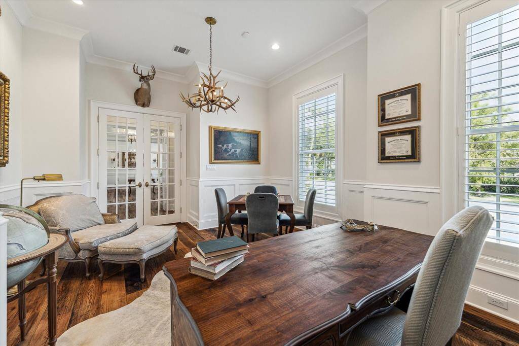 French doors with beveled glass grace expansive study, which boasts plantation shutters & ample room for game tables and sitting area.