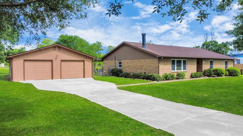 Charming single-story brick home with a recent roof install, featuring a spacious four+ car garage and a well-maintained front yard with lush green grass. **(Ask your realtor for the amenities list)**