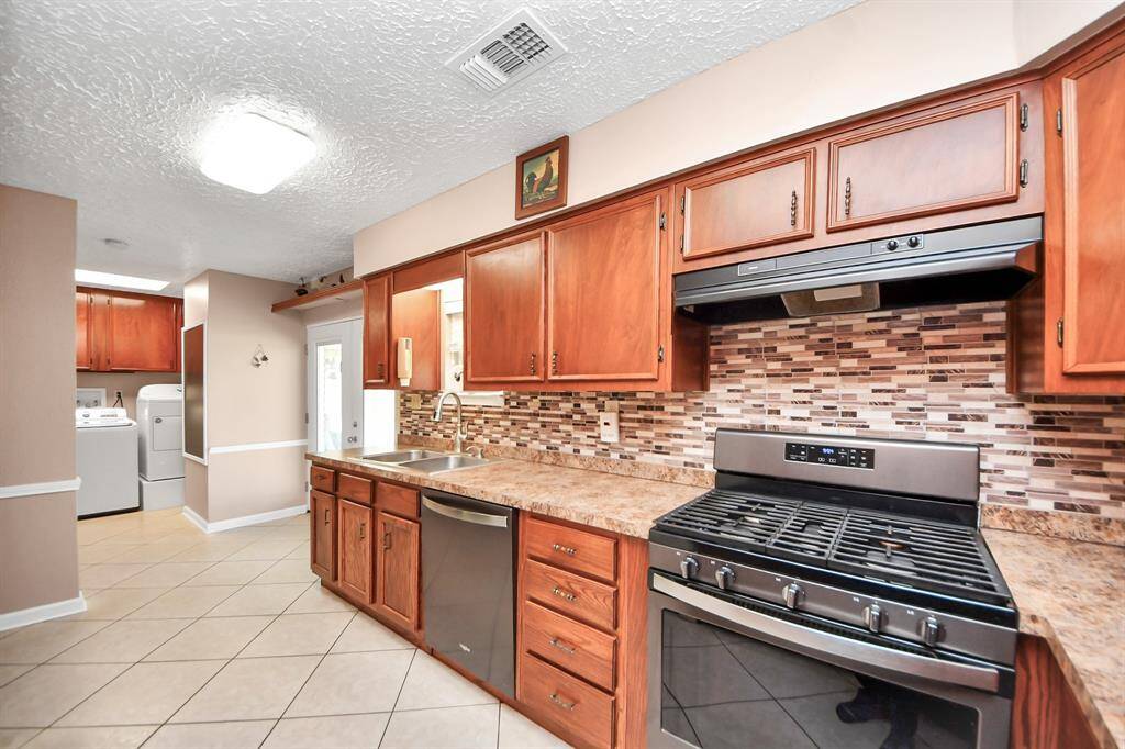 Large kitchen with custom wood cabinets, recent SS appliances.