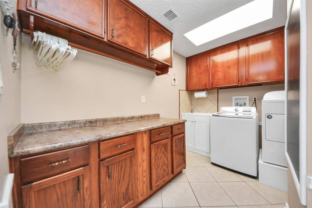 Laundry room with plenty of cabinetry for storage and a utility sink!