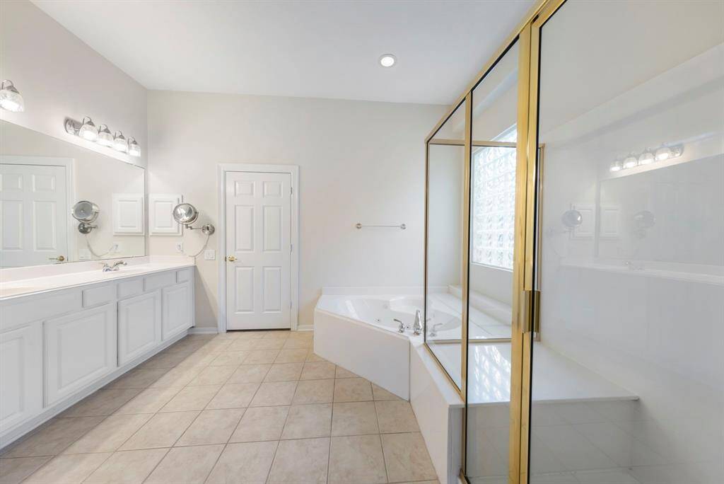 The primary bathroom offers a walk-in shower, relaxing jetted tub, and dual sinks.