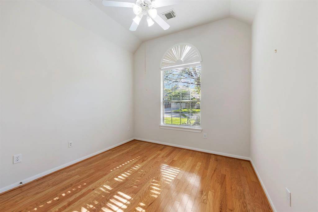 An additional secondary bedroom features wood flooring and a spacious walk-in closet.