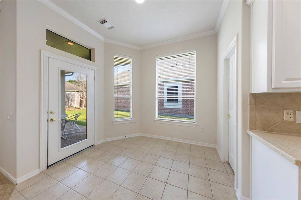 A cozy breakfast nook features a door that leads directly to the backyard patio with the walk-in pantry to the right.
