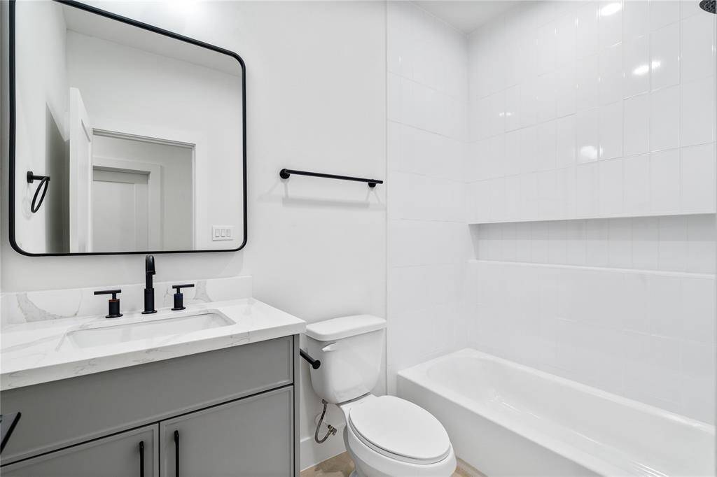 This private bath features high ceilings and ample lighting, creating a bright and spacious feel.
