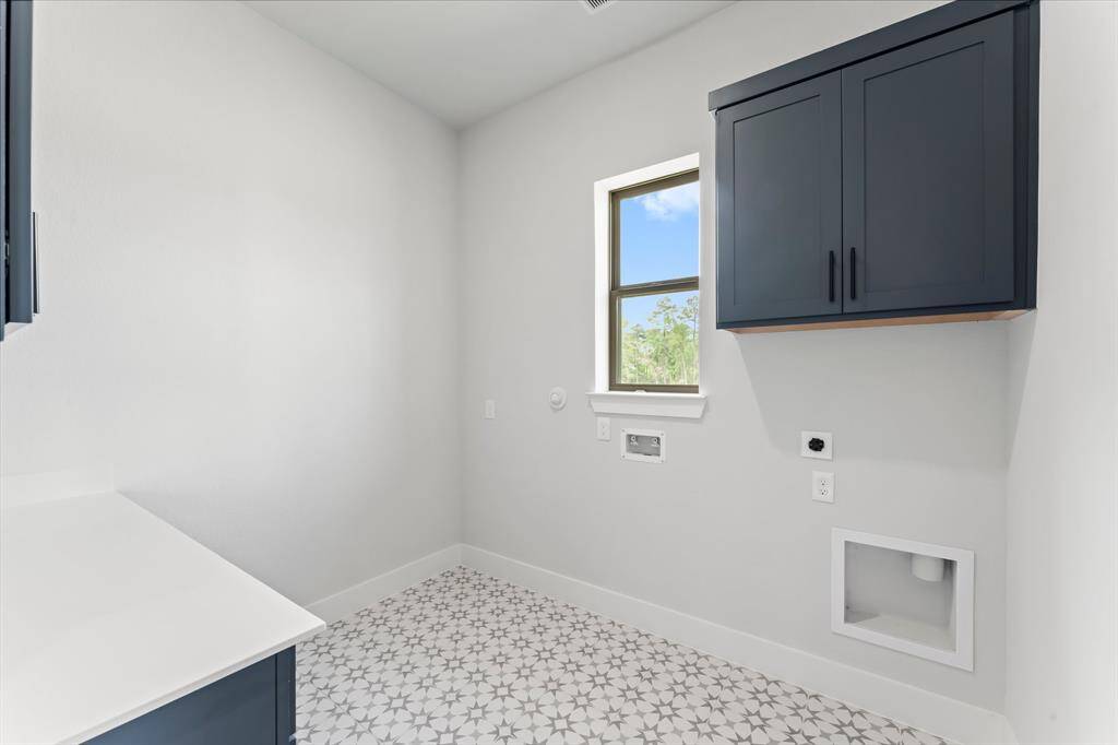 Utility Room with Washer and Dryer Connections, Storage Cabinets, and Tile Flooring