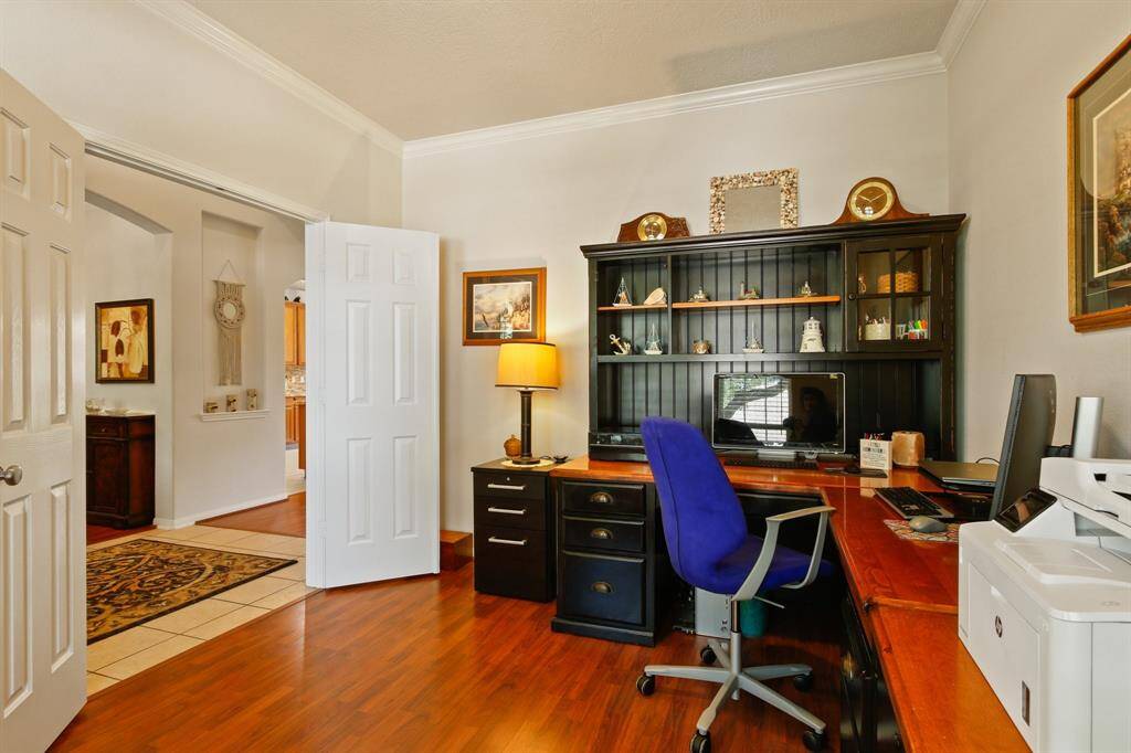 Elevate your productivity in this elegant study featuring double doors and sleek wood laminate flooring.