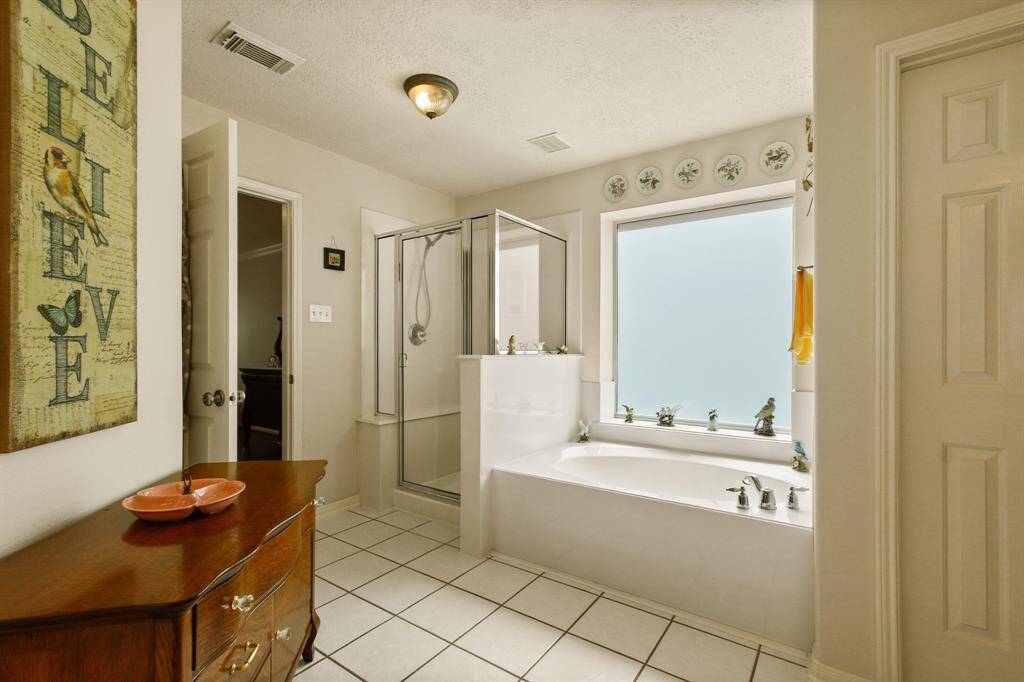 Luxurious primary bath featuring a relaxing tub and separate shower.