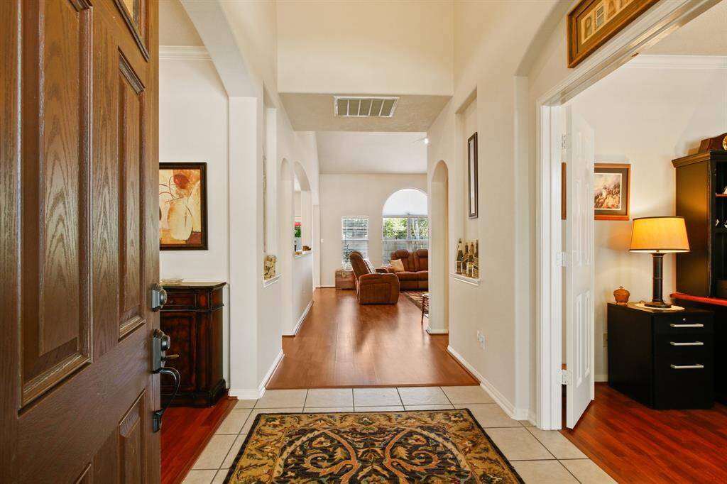 Inviting entryway featuring elegant tile and stylish wood-look flooring.
