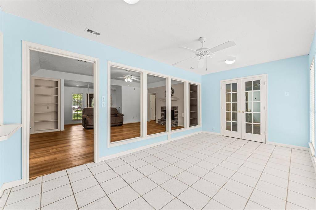 Beautiful sun room overlooks the sprawling backyard with a glittering pool and mature trees.