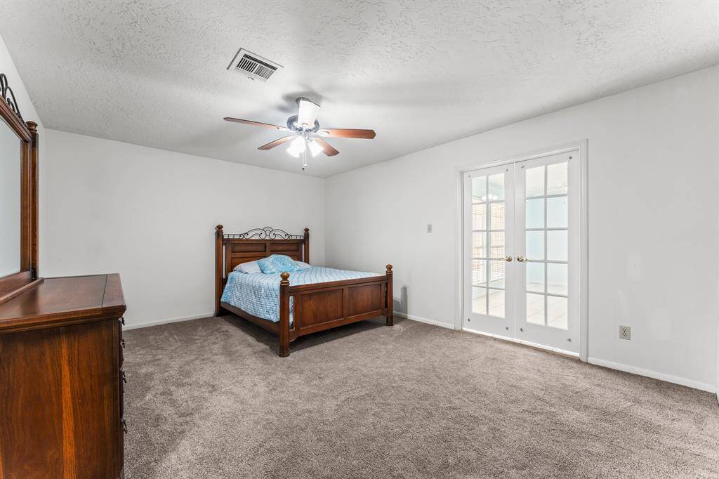 Large primary bedroom enjoys sunroom access - a perfect spot for your morning coffee.