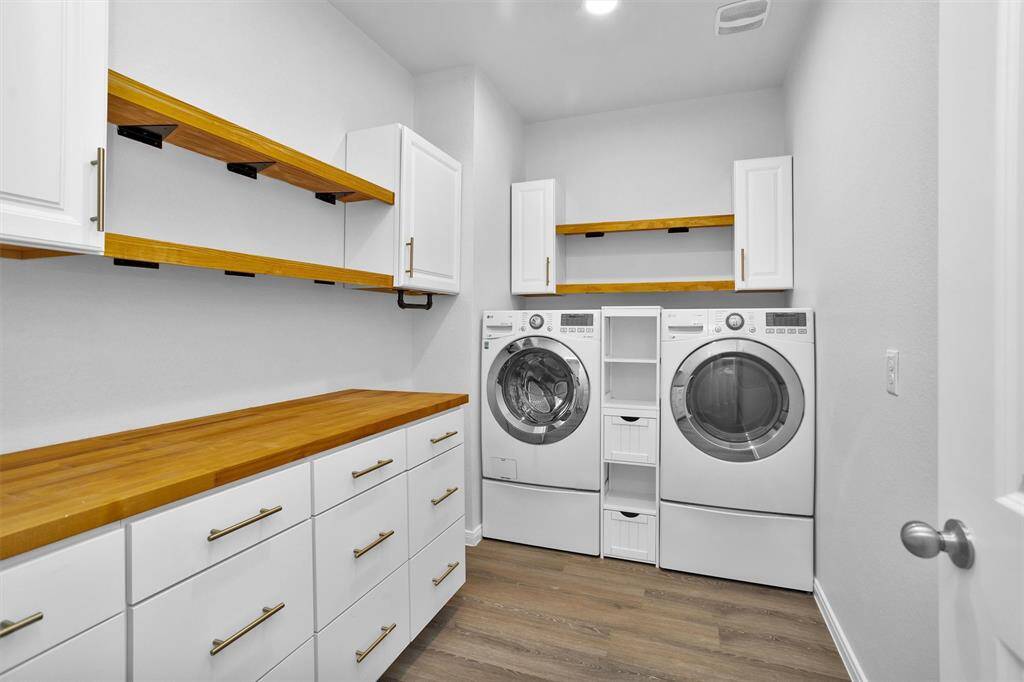 Functional laundry room with built-in shelving and space for full-size washer and dryer—tucked away yet easy to access.