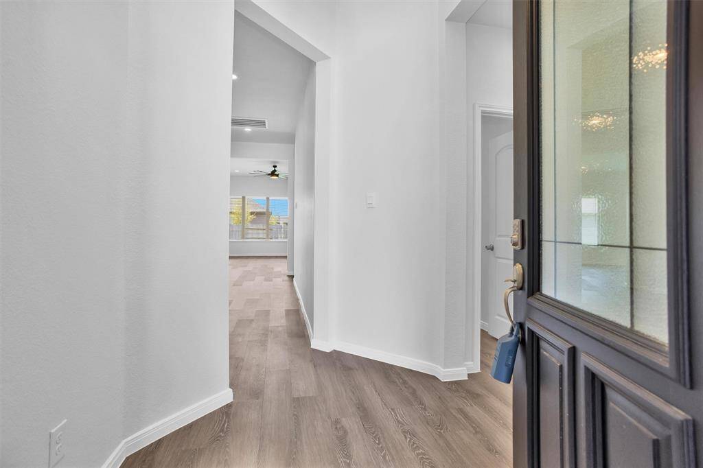 Step inside to a welcoming foyer with luxury vinyl plank flooring and clean, modern finishes. Natural light flows in, setting the tone for the open and inviting layout ahead.