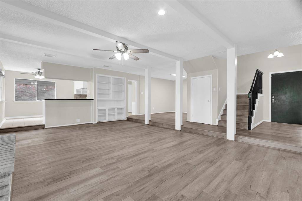 The open layout flows effortlessly from room to room, elevated by thoughtful architectural details like exposed beams, custom built-ins, and step-up transitions that define spaces while maintaining an airy feel.