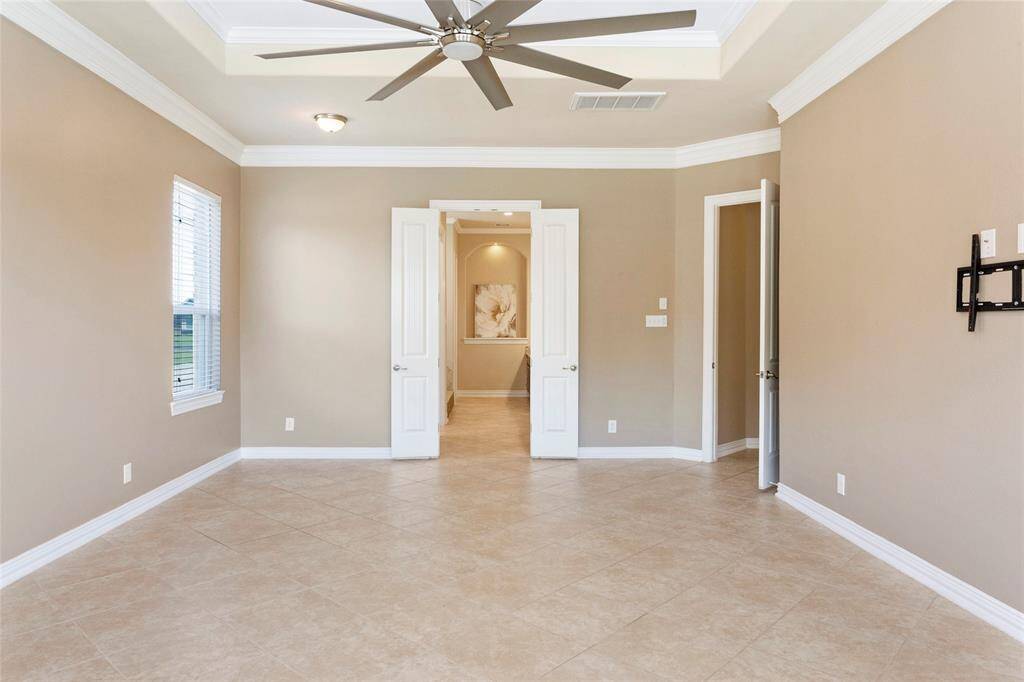 The Primary Bedroom features a tray ceiling with double crown molding, and French doors leading to the Primary Ensuite Bathroom.