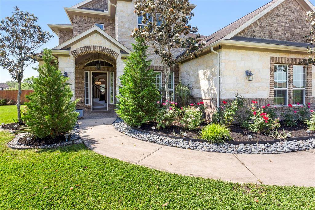 A welcoming arched, stone and brick entryway leads to a spacious front porch.