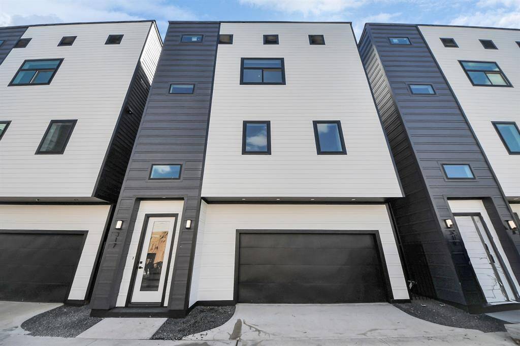 Welcome to 317 N Nagle Street! This sleek, modern home built by Tradewind East Court Development features a bold black exterior with Cemplank fiber cement siding and HardiePlank fascia, ensuring durability and style.