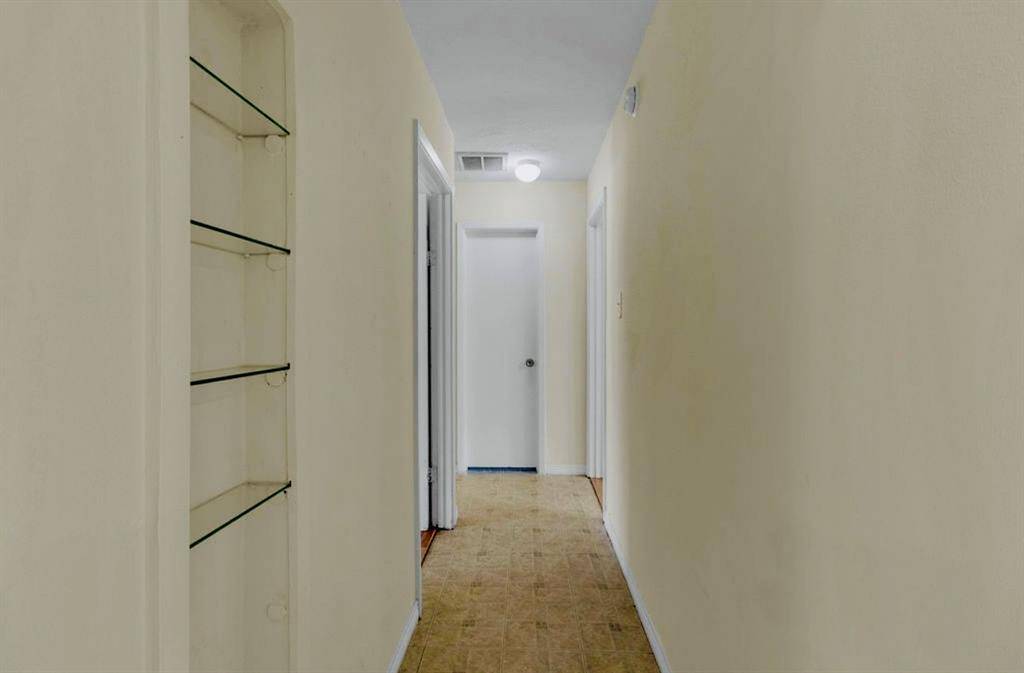 Hallway leads to guest bathroom and bedrooms