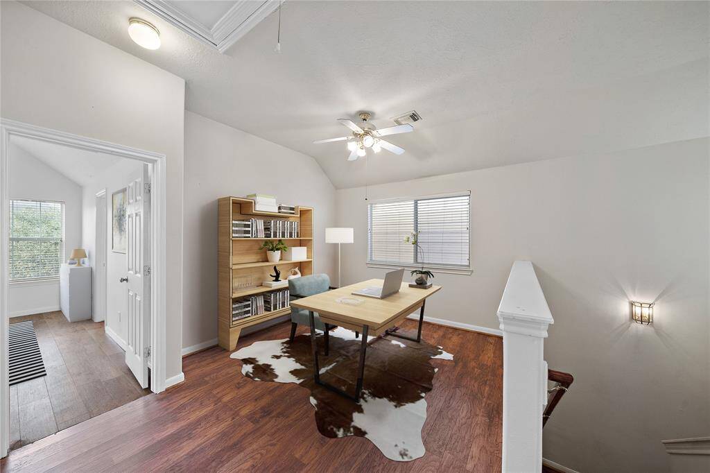 The upstairs second living area/flex space is a cozy, well-lit space with hardwood floors, a ceiling fan, and a large window to let in all the natural light. Absolutely wonderful space that can be used as an office, play room, second living room, game room, and more.