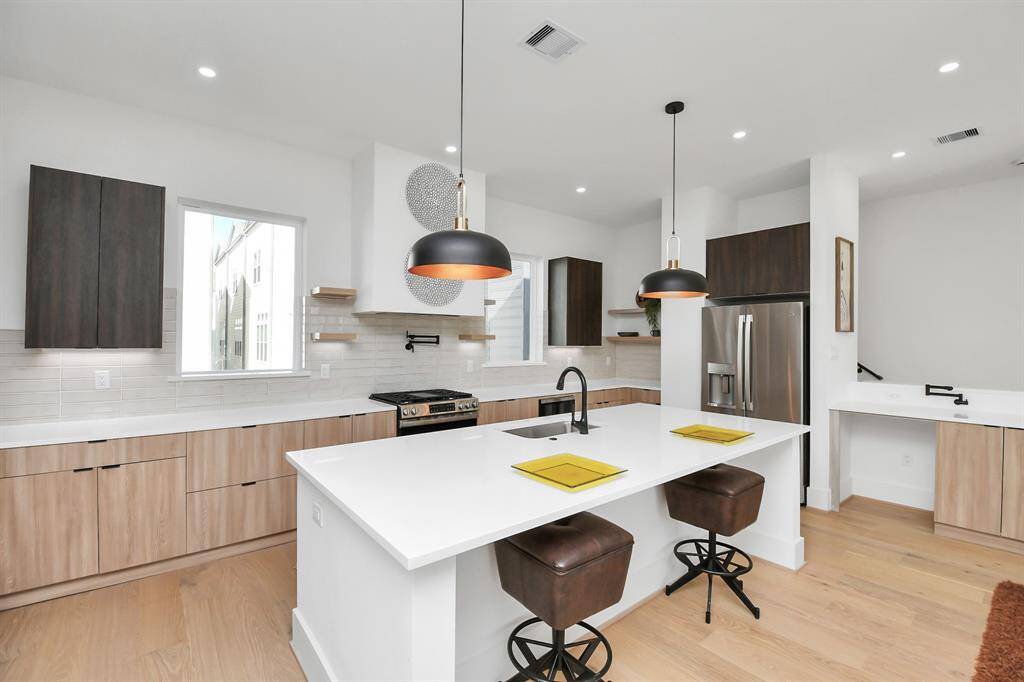 The island includes an overhang for seating, creating a perfect breakfast bar for casual meals or entertaining guests.