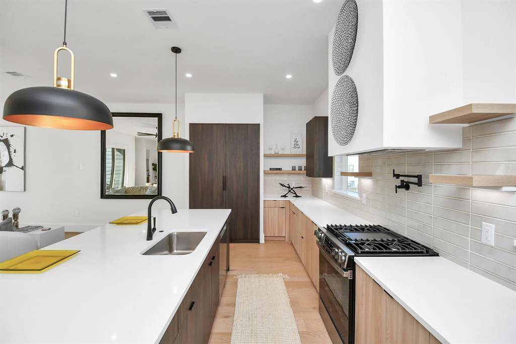 Sleek, modern cabinetry in a rich wood finish provides plenty of storage, complemented by floating shelves for decorative and functional display.