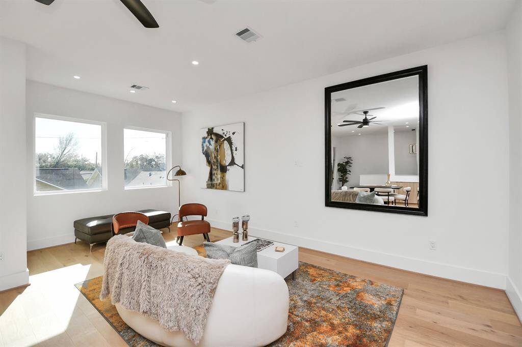 The spacious living room is filled with natural light from large windows, creating an inviting and airy atmosphere.