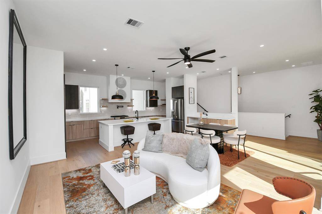 This open-concept living space is conveniently connected to the kitchen and dining area, making it ideal for gatherings and socializing.